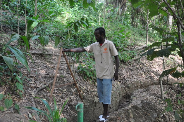 A worker at Fondes Amandes demonstrates the building of fire traces. Credit: Desmond Brown/IPS