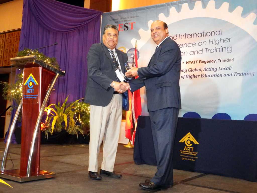 ACTT Executive Director Michael Bradshaw (left) presents Tertiary Education Minister Fazal karim (right) with a token during the opening of ACTT’s Second International Conference on higher Education and Learning at the Regency Ballroom, Hyatt.