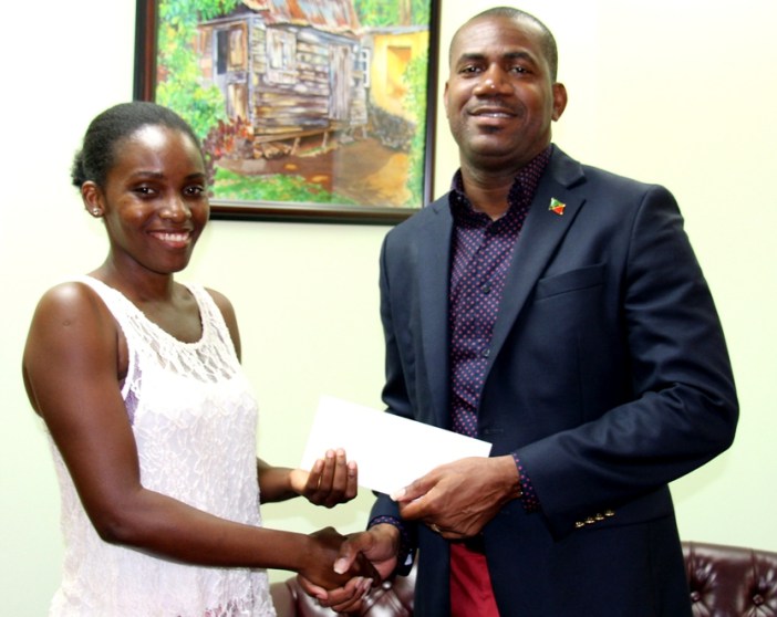 St. Kitts and Nevis Deputy PM Richards presents support to Ms. Elliott for her travel to Silicon Valley. (Photo courtesy the Department of Youth Empowerment)
