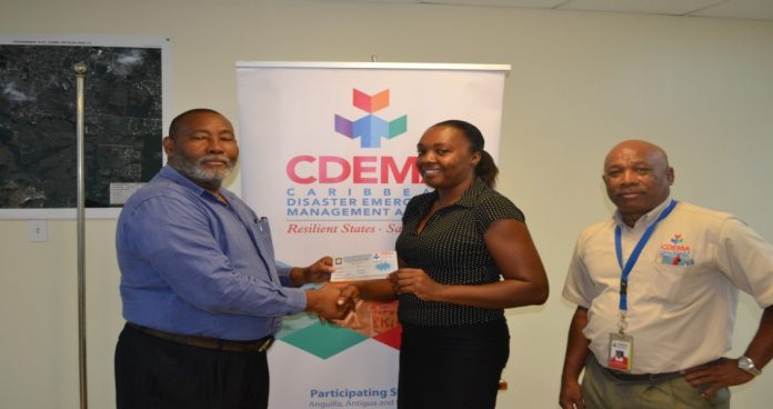 Philmore Mullin, Director of NODS, Antigua & Barbuda and Brigadier General (Rtd) Earl Arthurs, Consultant with the CDEMA CU captured above presenting a Grocery Voucher to Salome Deazle.