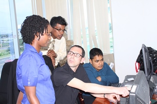 Mr. Sebastien Cadic (centre) Team Leader, Merchandise Trade Statistics Project, ARTEMIS Information Management, makes a point to Ms. Marissa Ramotar of the Regional Statistics Programme, CARICOM Secretariat, as her colleagues Mr. Deo Persaud and Mr.