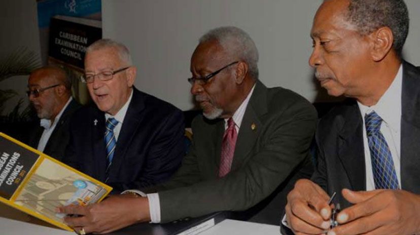 Former Prime Minister, the Most Hon. P.J. Patterson (2nd right), and Education Minister, Hon. Rev. Ronald Thwaites (2nd left), peruse a copy of the newly published book, ‘A History of the Caribbean Examination Council, 1973-2013’, written