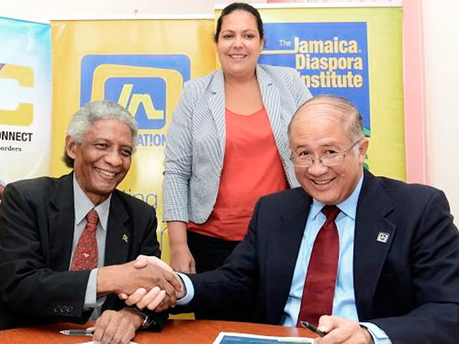 Professor Neville Ying (left), executive director, Jamaica Diaspora Institute, and Parris Lyew-Ayee, director, Jamaica National Building Society Foundation, shake hands after they affixed their signatures to formalise the funding agreement between th