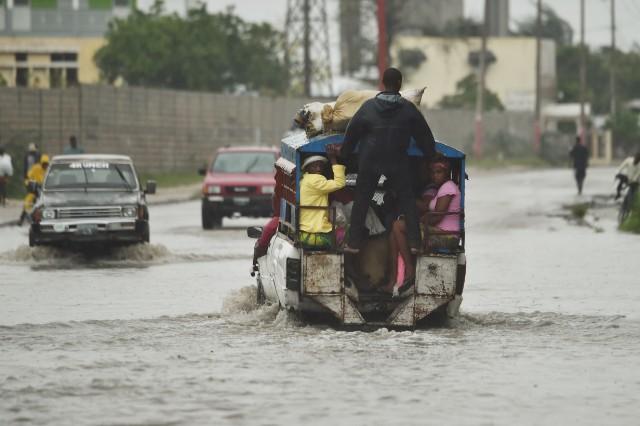 A tap tap (public transportation) crosses a flooded street in Port-au-Prince after Hurricane Matthew made landfall in Southwestern Haiti, on Oct. 4, 2016. (Photo via Time)