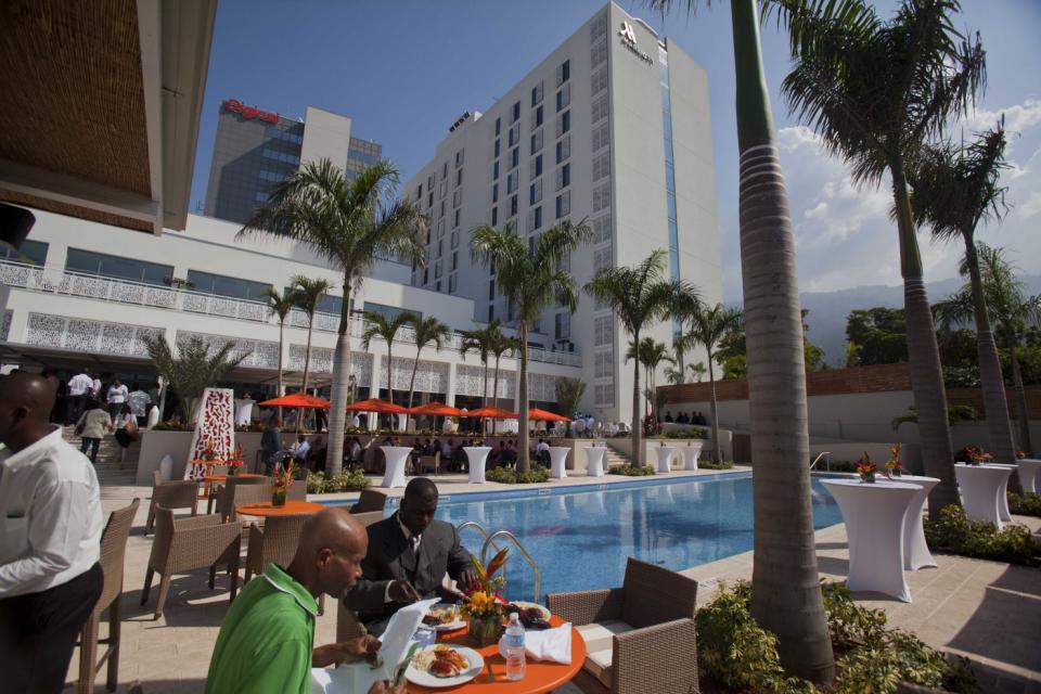 People eat near the pool at the new Marriott hotel after the hotel&rsquo;s opening ceremony in Port-au-Prince, Haiti, Tuesday, Feb. 24, 2015. Haiti&rsquo;s second international-branded hotel opened Tuesday in what backers of the project and officials