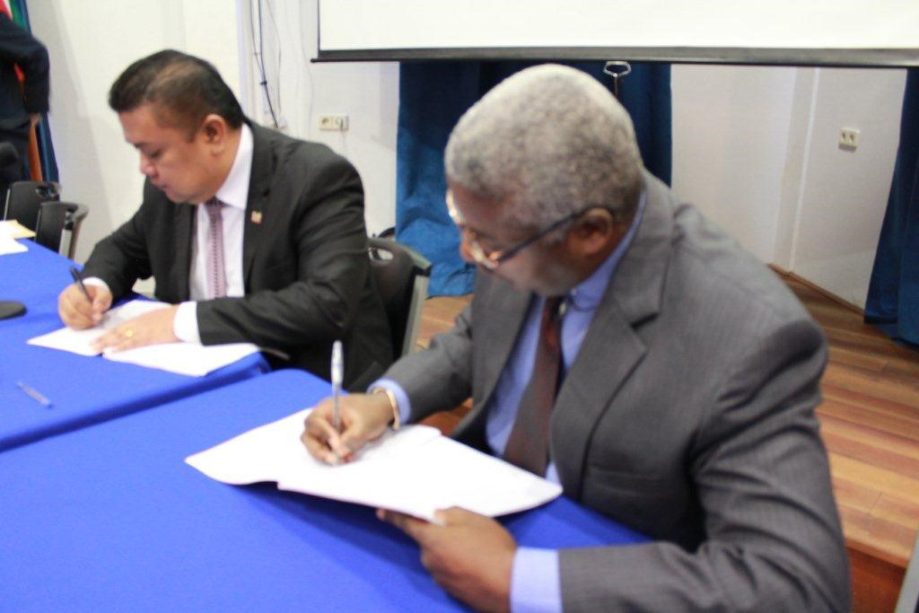 Edward Greene, Division Chief of the Technical Cooperation Division of the CDB, signs the agreement with Minister of Trade and Industry, Don Soejit Tosendjojo