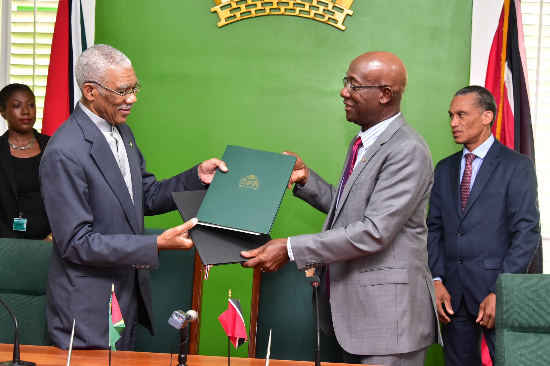 President David Granger and Prime Minister Keith Rowley exchange copies of the MOU (Photo via Ministry of the Presidency)