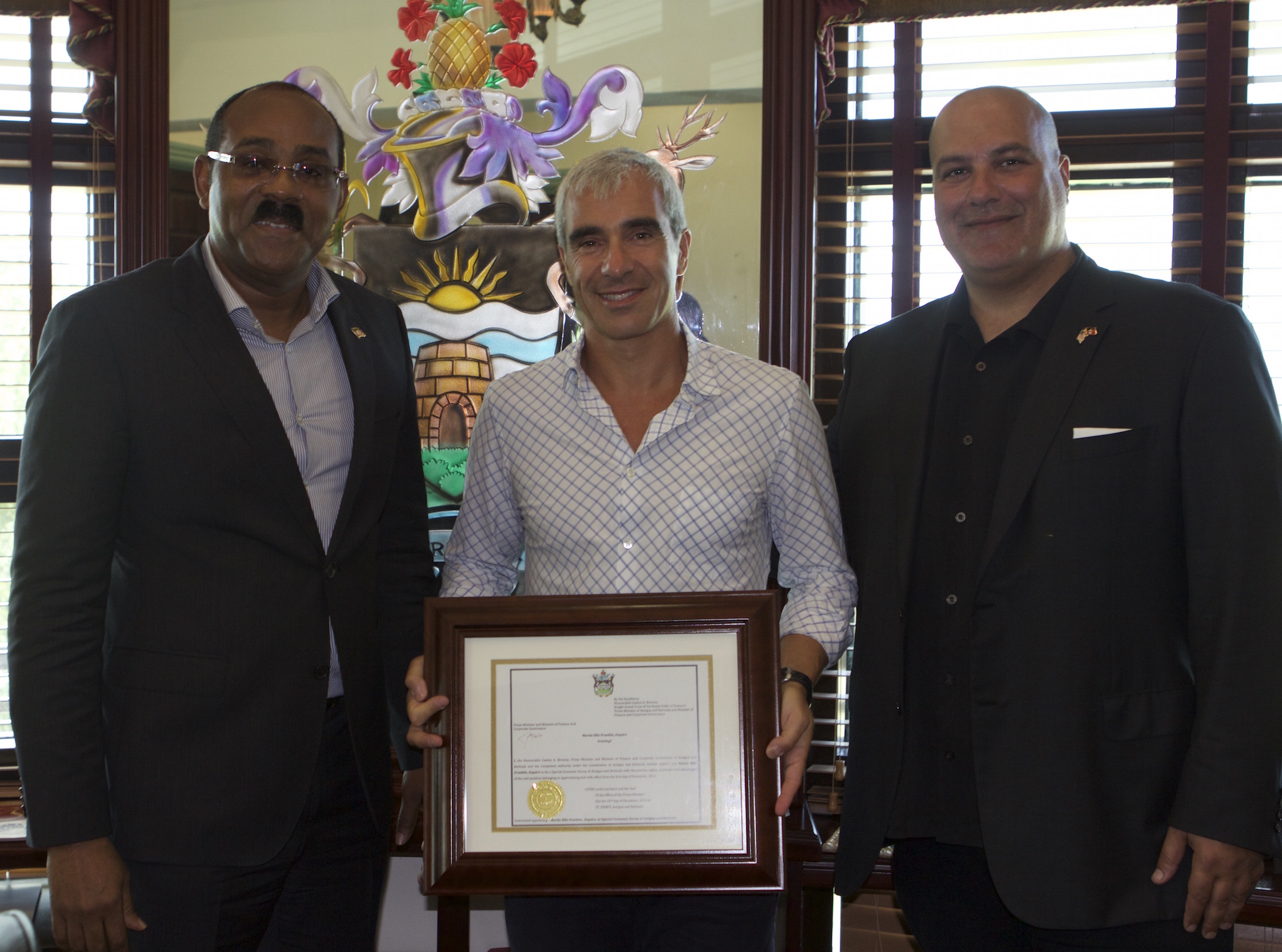 PM Browne presenting the Instrument of Appointment to Mr. Martin Franklin. Ambassador Boustany was on hand for the presentation.