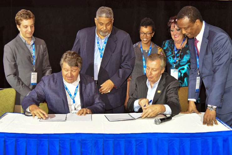 Director General and CEO of CHTA Frank Comito (seated at right) and USAID CARCEP’s Energy Efficiency Promotion Specialist John Marcocchio at yesterday’s signing in Puerto Rico. Standing from left is Jonathan Schwartz of Deloitte Consultin