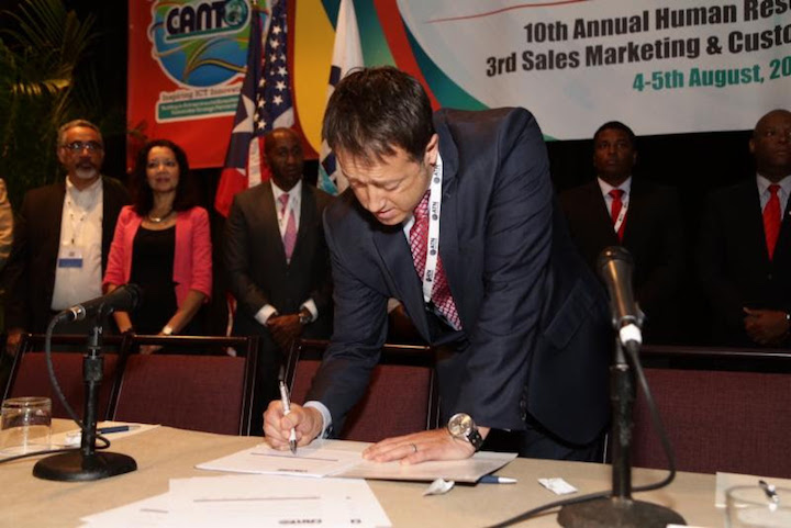 John Reid Interim CEO of C&amp;W Communications flanked by CEOs and Country Managers signs Code of Practice