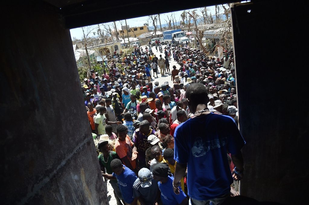 Hurricane Matthew victims wait to receive food from the UN's World Food Programme in Roche-a-Bateaux, in Les Cayes, in the south west of Haiti, on October 12, 2016 Hurricane Matthew victims wait to receive food from the UN's World Food Prog