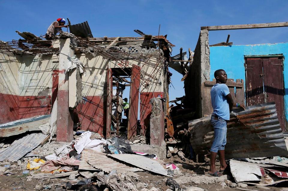 Men salvage metal sheets from a destroyed house after Hurricane Matthew passes in Jeremie, Haiti (CARLOS GARCIA RAWLINS/REUTERS)