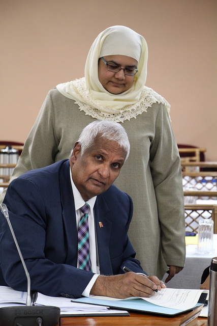 Trinidad and Tobago&rsquo;s Foreign Minister Hon. Winston Dookeran signs protocol as General Counsel at the CARICOM Secretariat Safiya Ali looks on