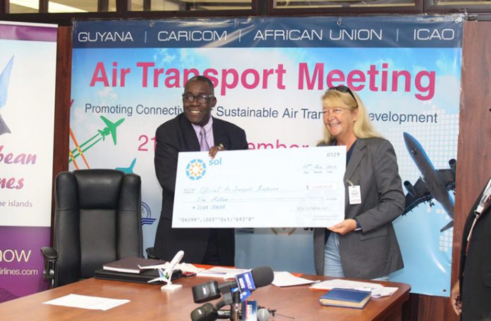 General Manager, SOL Aviation Guyana, Liz Wyatt hands over a cheque for $1M to Franklin &lsquo;Bobby&rsquo; Vieira, Director of Marketing and Operational Support on Friday (DPI)