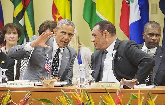 US President Barack Obama talks with Prime Minister Perry Christie at the summit with Caribbean Community (CARICOM) leaders yesterday in Kingston, Jamaica. The president said that will he soon decide whether to remove Cuba from the US list of state s