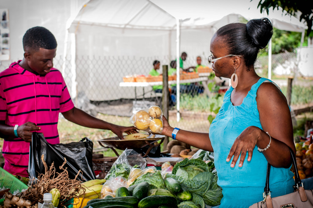 A patron purchases local produce at 2014 Agriculture Open Day