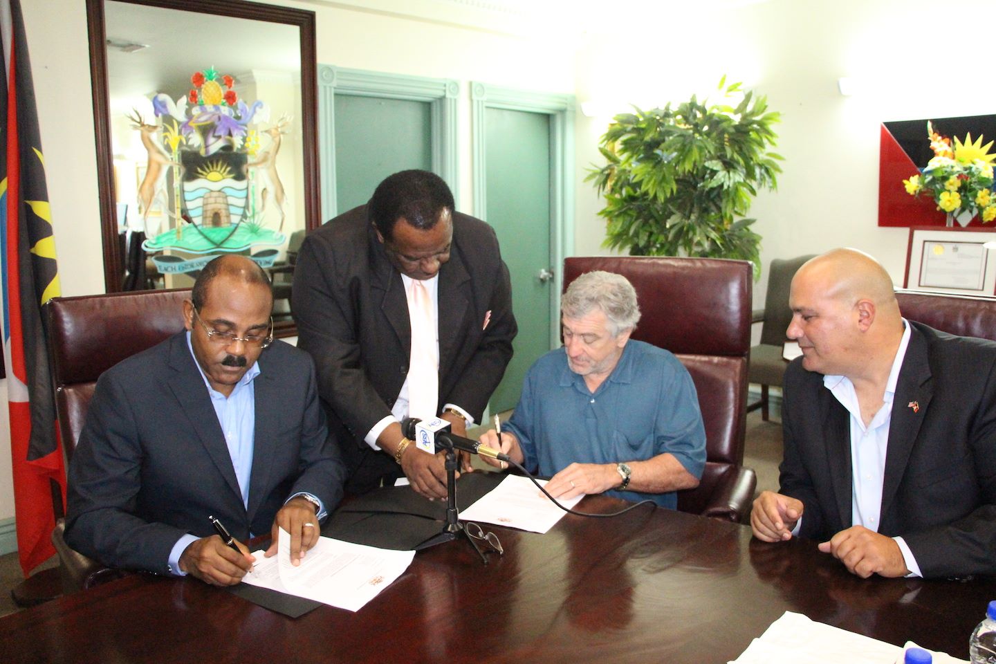 Prime Minister of Antigua and Barbuda, the Hon. Gaston Browne signs the agreement with actor Robert DeNiro
