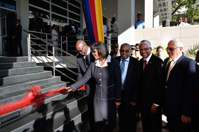 Prime Minister, the Most Hon. Portia Simpson Miller (2nd left), is assisted by Minister of Health, Hon. Dr. Fenton Ferguson (left), as she cuts the ribbon to officially open the $4 billion state-of-the-art Faculty of Medical Sciences Teaching and Res